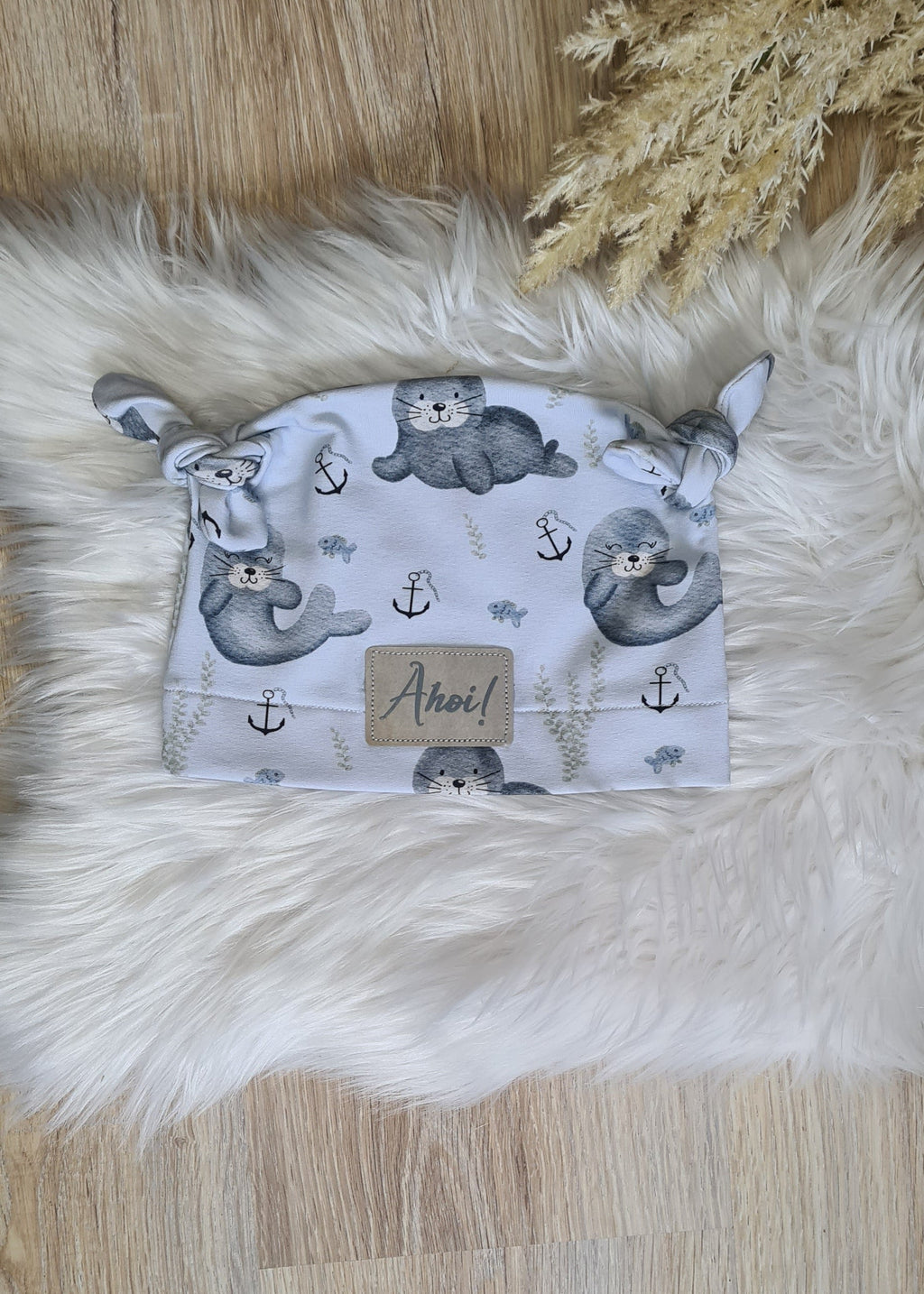 Baby Knoten-Mütze "Rudi die Robbe" Detailansicht Robben-Motiv, French Terry 95% Baumwolle 5% Elasthan – passend zur Strampler-Kollektion | Little Falili
