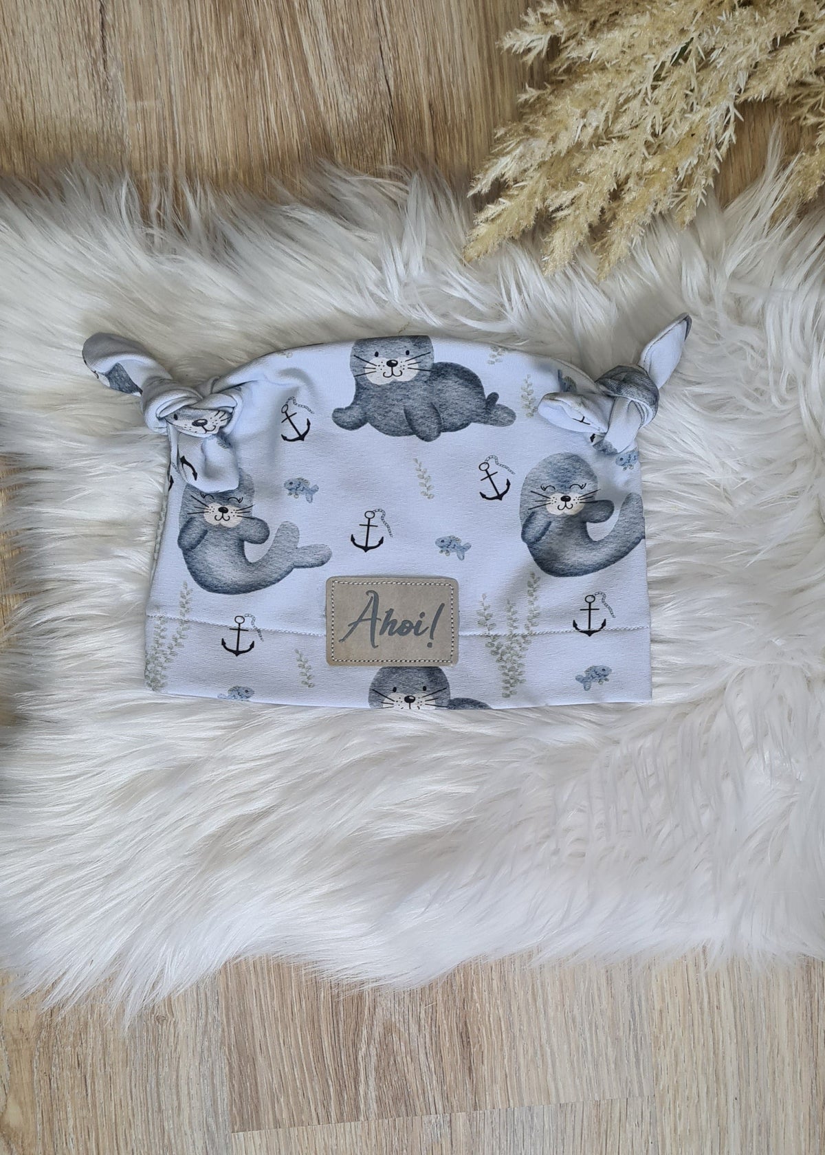 Baby Knoten-Mütze "Rudi die Robbe" Detailansicht Robben-Motiv, French Terry 95% Baumwolle 5% Elasthan – passend zur Strampler-Kollektion | Little Falili
