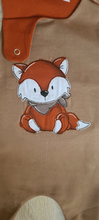 Nahaufnahme Fuchs-Stickerei auf braunem Baby-Strampler aus Jersey