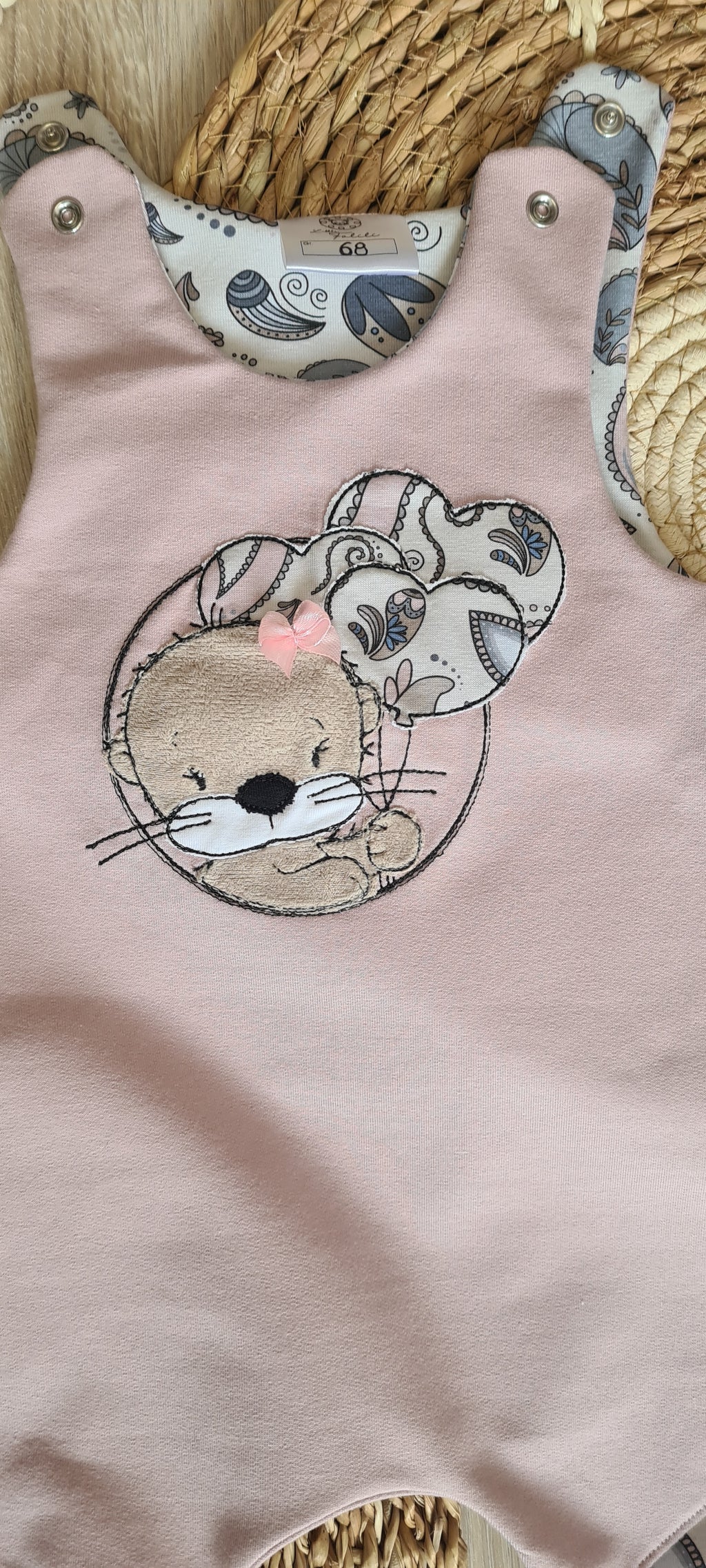 Nahaufnahme Otter-Stickerei auf rosafarbenem Baby-Strampler, handmade Little Falili