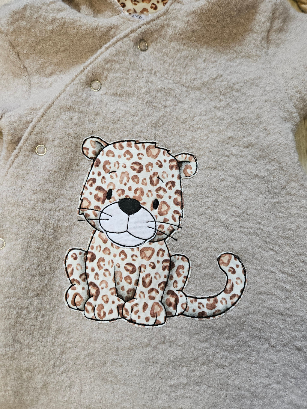 Leoparden-Applikation auf einem beigen Wollwalkanzug für Kinder