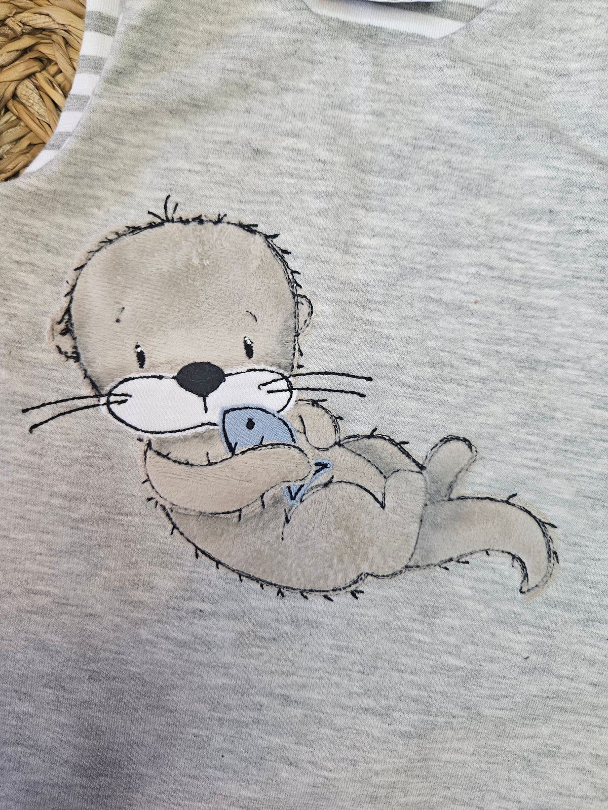 Baby Strampler "Otter mit Fisch grau" Detailansicht Otter-Stickmotiv in grau, French Terry & Jersey, 95% Baumwolle 5% Elasthan – Mütze separat erhältlich | Little Falili
