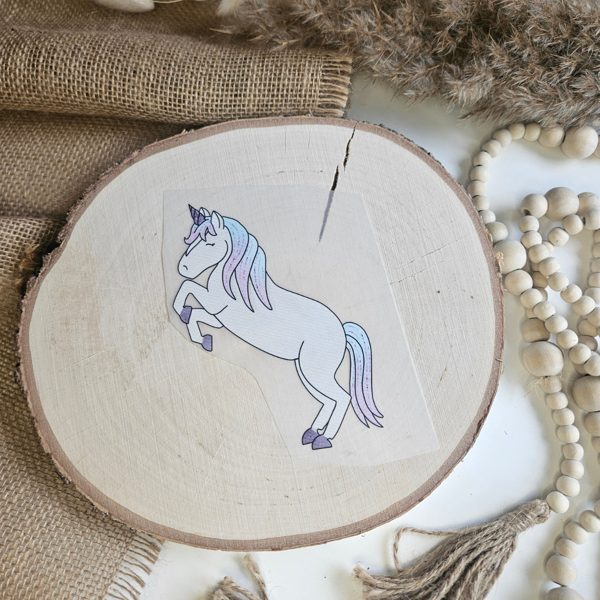 "Einhorn" Bügelbild zum Aufbügeln – steigendes Einhorn-Motiv im Aquarellstil mit hellblauer Mähne auf Holzscheibe, handmade | Little Falili
