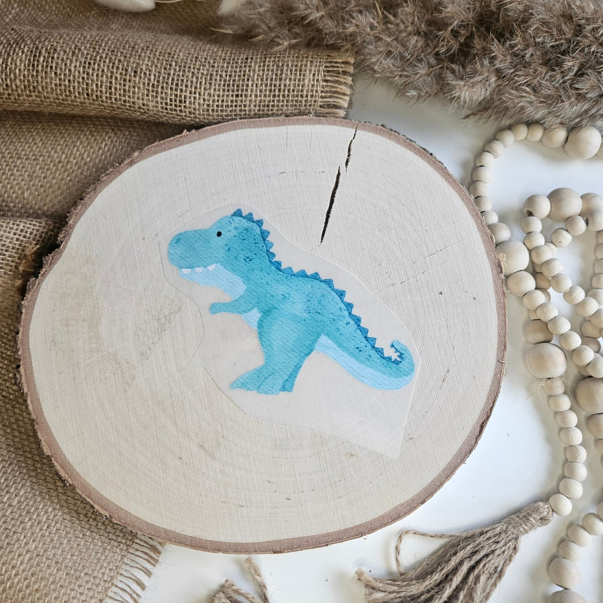 "Dino grün" Bügelbild zum Aufbügeln – niedlicher türkis-blauer T-Rex im Aquarellstil auf Holzscheibe, handmade | Little Falili
