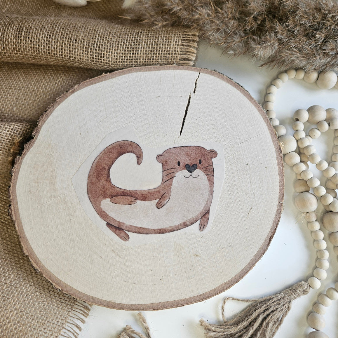 "Olli Otter 2" Bügelbild zum Aufbügeln – niedlicher rollender Otter im Aquarellstil auf Holzscheibe, handmade | Little Falili
