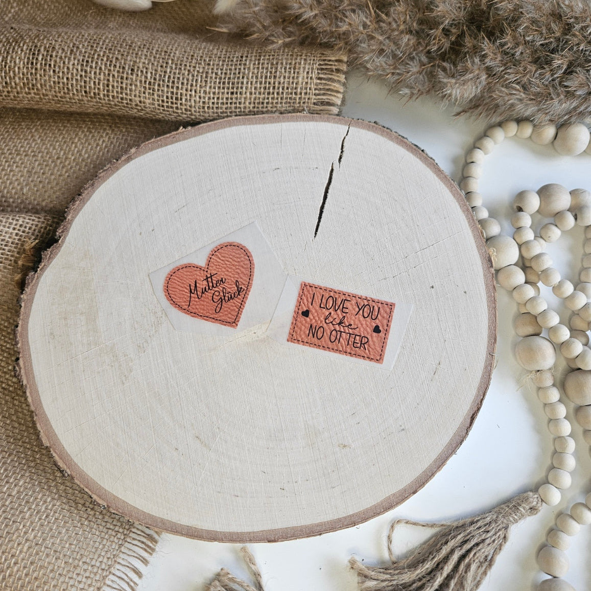"Label" Bügelbild zum Aufbügeln – zwei Label-Motive: Herz mit "Mutterglück" und Rechteck mit "I love you like no Otter" auf Holzscheibe, handmade | Little Falili
