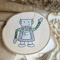 "Roboter 2" Bügelbild zum Aufbügeln – niedlicher grau-grüner Roboter mit winkenden Kugelarmen im Aquarellstil auf Holzscheibe, handmade | Little Falili
