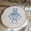 "Roboter 1" Bügelbild zum Aufbügeln – niedlicher grau-grüner Roboter mit herzförmigem Körper und Antennen im Aquarellstil auf Holzscheibe, handmade | Little Falili

