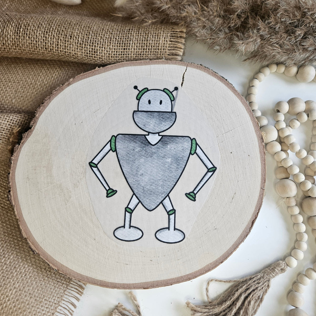 "Roboter 1" Bügelbild zum Aufbügeln – niedlicher grau-grüner Roboter mit herzförmigem Körper und Antennen im Aquarellstil auf Holzscheibe, handmade | Little Falili
