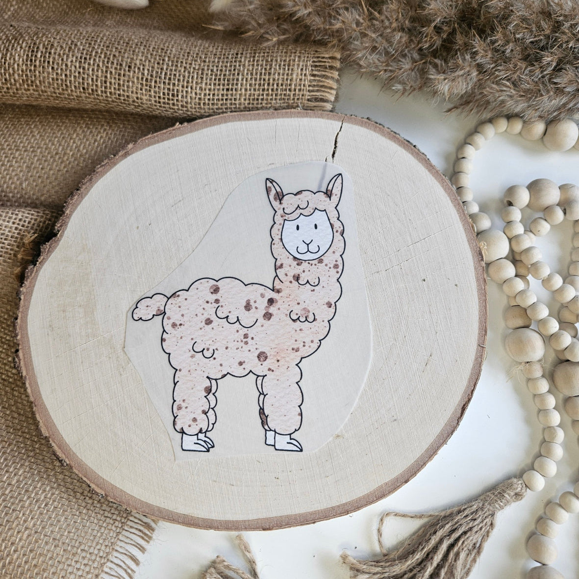 "Lama beige" Bügelbild zum Aufbügeln – niedliches beiges Lama mit fluffigem Fell im Aquarellstil auf Holzscheibe, handmade | Little Falili
