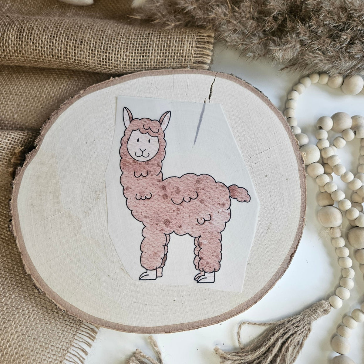 "Lama braun" Bügelbild zum Aufbügeln – niedliches braun-rosafarbenes Lama mit fluffigem Fell im Aquarellstil auf Holzscheibe, handmade | Little Falili
