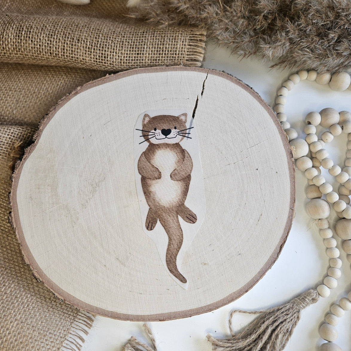 "Otter" Bügelbild zum Aufbügeln – niedlicher schwimmender Otter mit Herzchen-Nase im Aquarellstil auf Holzscheibe, handmade | Little Falili
