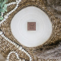 Braunes PU-Kunstlederlabel mit dem Schriftzug „Frechdachs“ auf einer hellen Holzscheibe im natürlichen Boho-Stil.