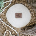 Braunes PU-Kunstlederlabel mit dem Schriftzug „Wild one“ auf einer hellen Holzscheibe im natürlichen Boho-Stil.