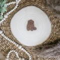 Braunes PU-Kunstlederlabel mit  „Biber“  auf einer hellen Holzscheibe im natürlichen Boho-Stil.