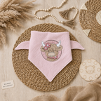 Kinderhalstuch mit liebevollem Stickmotiv Hochland Rind im Boho-Mockup auf hellem Holzuntergrund, Bild wurde mit KI erstellt
