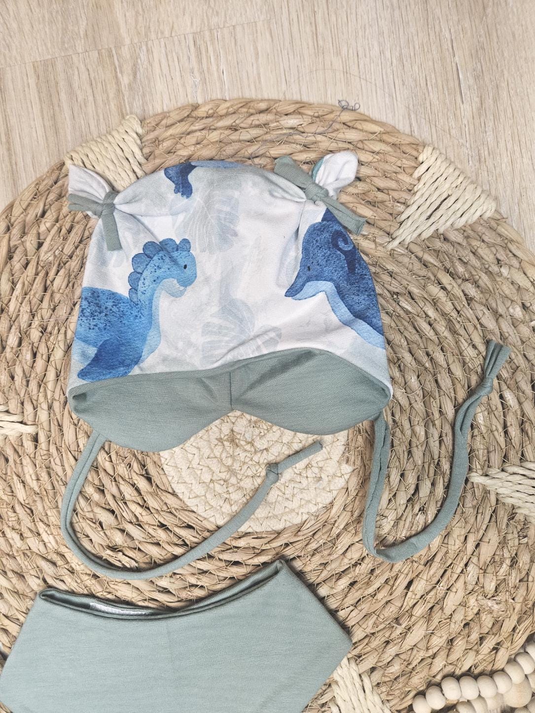 Baby Öhrchen-Mütze "Dinos" mit Dino-Allover-Muster, handgemacht aus French Terry & Jersey, 95% Baumwolle 5% Elasthan – passend zum Dinos-Strampler | Little Falili
